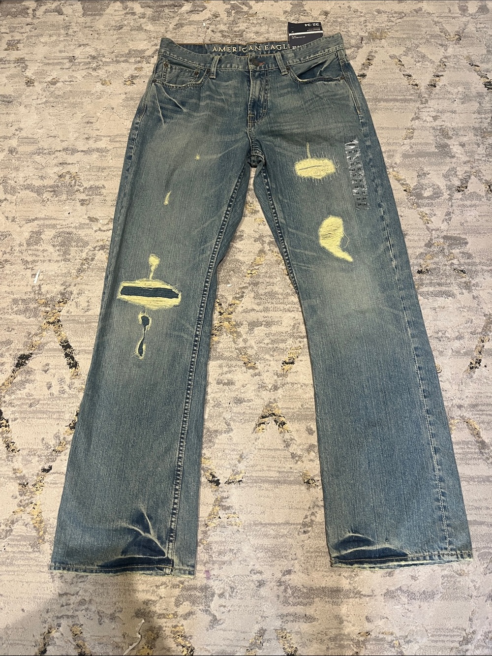 American Eagle Outfitters Men's Blue Bootcut Jeans with Yellow Distress